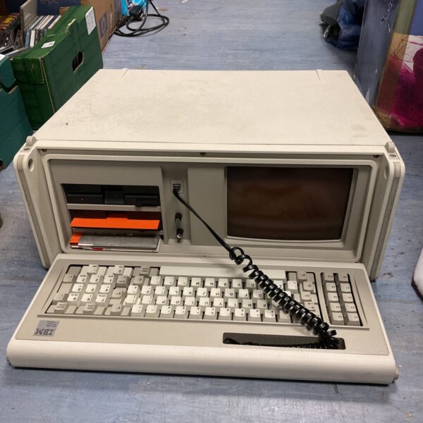 Vintage IBM portable computer with keyboard and screen.