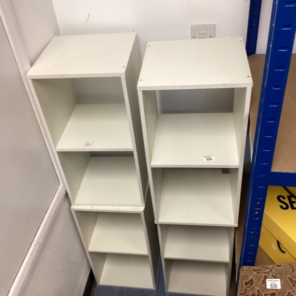 Lot of four white shelving units for home storage.
