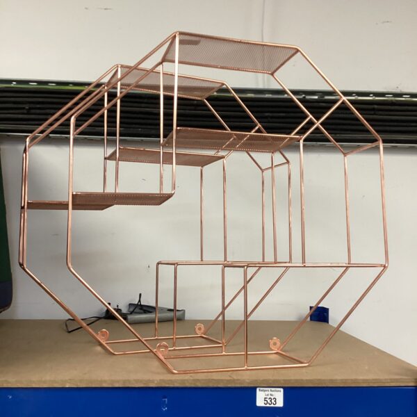 Rose gold hexagonal wire display shelf for home decor.
