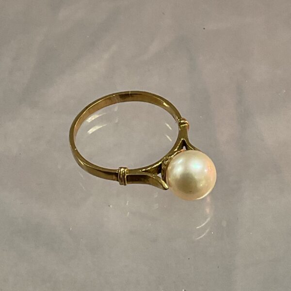 Close-up of a 9ct gold pearl ring with a single pearl.