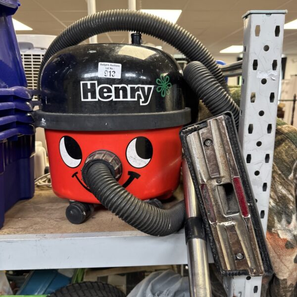 Red Numatic Henry cylinder vacuum cleaner with hose attached.