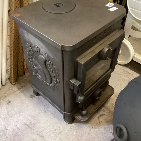 Antique cast iron wood burning stove with ornate detailing.