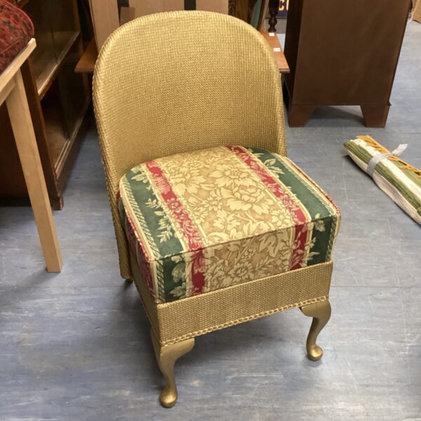Vintage Lloyd Loom bedroom chair with patterned upholstery.