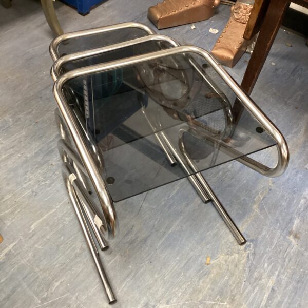 Chrome and glass nest tables with a mid-century modern design.