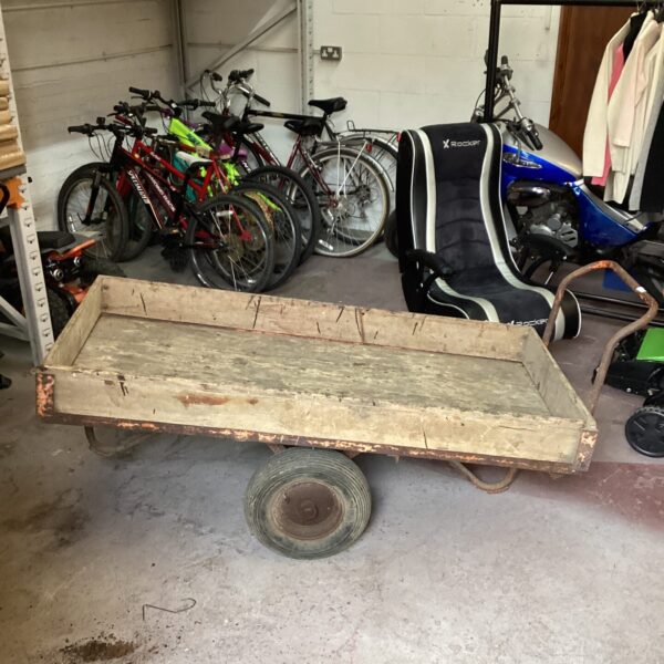 Rustic vintage wooden garden cart with weathered wood and wheels.