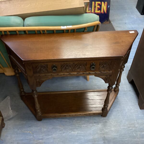 Antique oak hall table with lower shelf in a vintage setting.