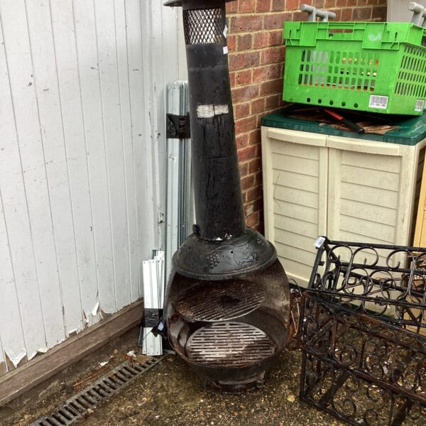 Rustic iron garden chimenea with weathered finish.