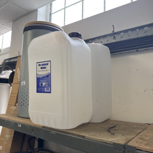 Empty 25 litre plastic water barrel for storage.