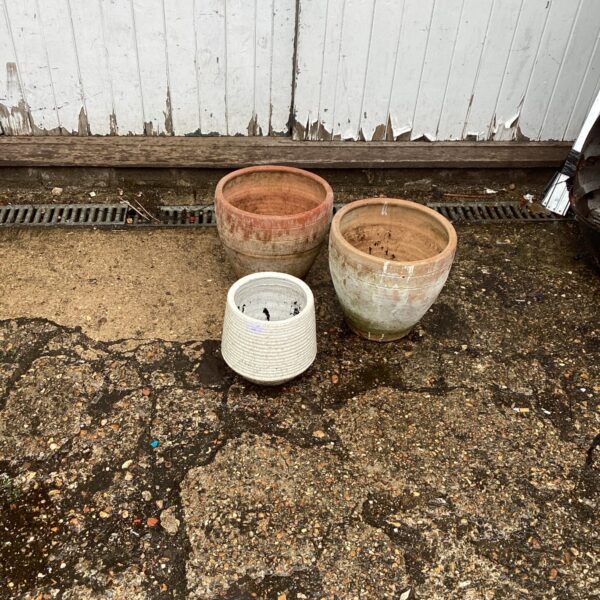 Lot of three weathered terracotta garden pots for plants.