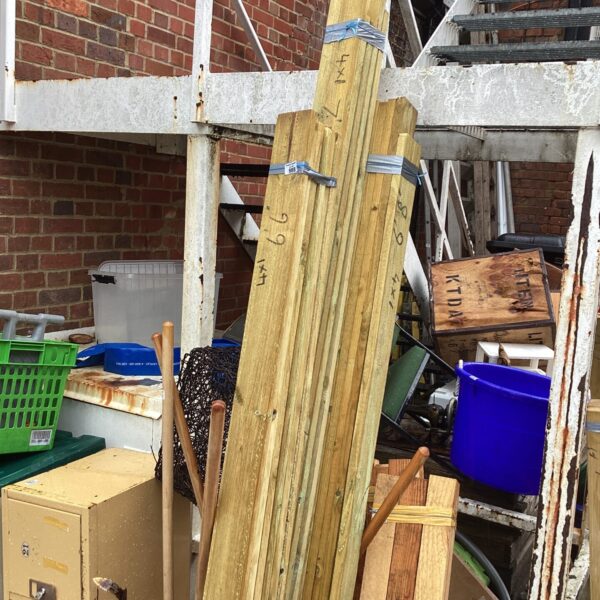Three bundles of 6’6” timber stored outdoors, ready for construction.