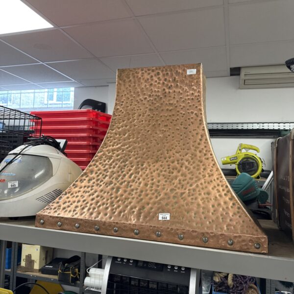 Vintage copper fire hood with curved design and aged patina.