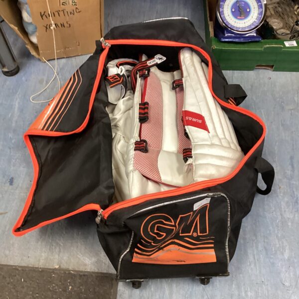 GM cricket kit bag with contents visible.