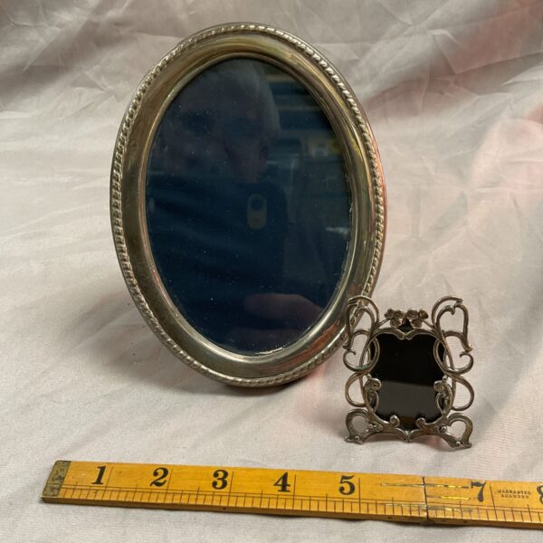 Antique sterling silver photograph frames with ornate detailing.