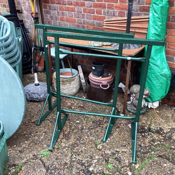 Green metal trestles pair in a garden setting.