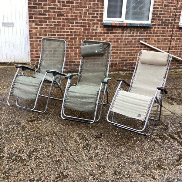 Three vintage sun loungers in a garden setting.