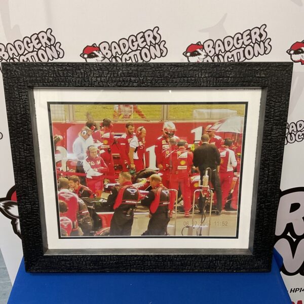 Vibrant Ferrari Formula One team print in the pit lane.