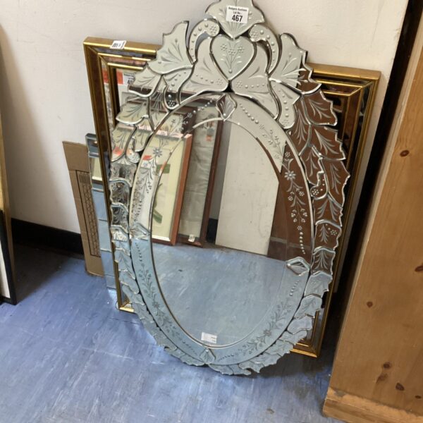 Ornate gilded decorative mirror with floral details and a vintage aesthetic.