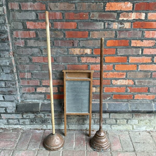 Antique set of copper washing dollies and wooden washboard for vintage laundry.