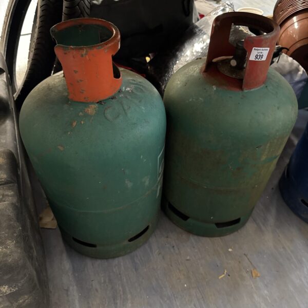 Two red Calor gas bottles for outdoor heating and camping.