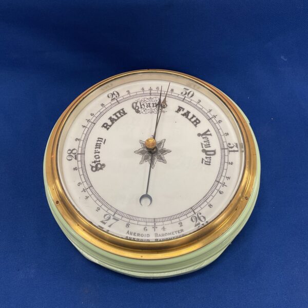 Vintage brass aneroid barometer displaying weather conditions.