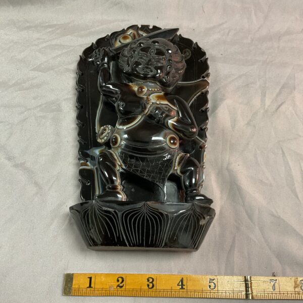 Antique jadite carving of a Buddhist figure with intricate details.
