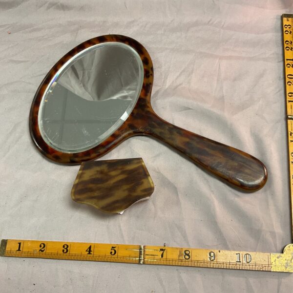 Vintage tortoiseshell hand mirror for vanity or travel.