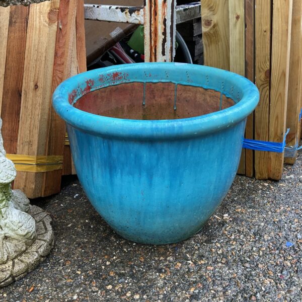 Large turquoise glazed ceramic plant pot for garden display.