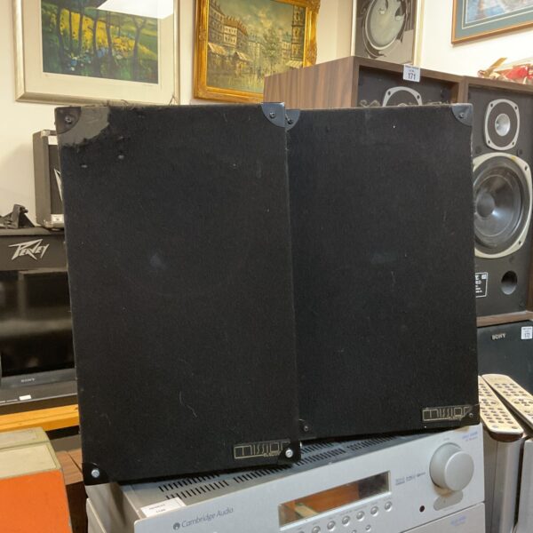 Pair of vintage Mission Model 77 bookshelf speakers in a home setting.