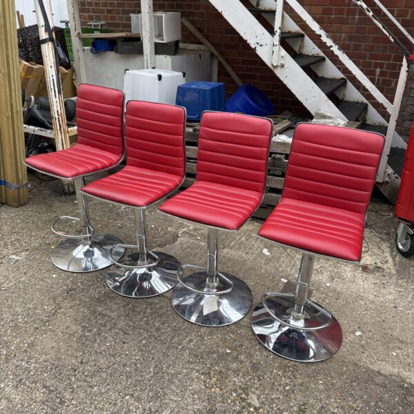 Set of four red bar stools with chrome bases.