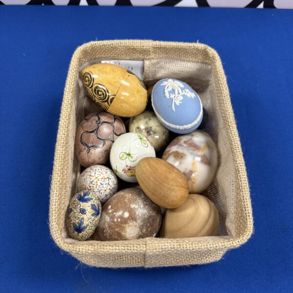 Close-up of ceramic and wooden eggs on a canvas tray.