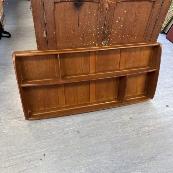 Vintage Ercol plate rack for displaying decorative plates.