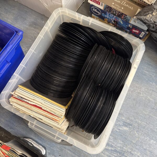 Stack of vintage 7 inch vinyl records in a box.