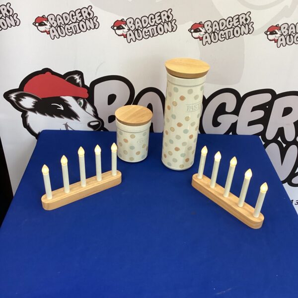 Kitchen storage jars and candle set on a patterned surface.