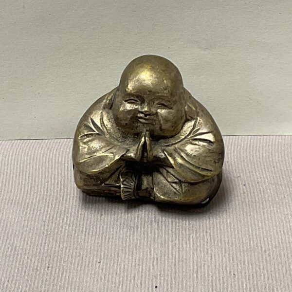 Small whitemetal Buddha statue with serene expression.