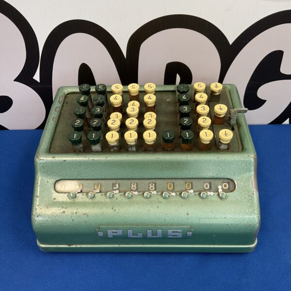 Vintage a.plus adding machine with numbered keys and levers.