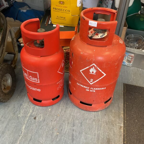 Two empty gas bottles, one Calor and one Valdo, for camping.