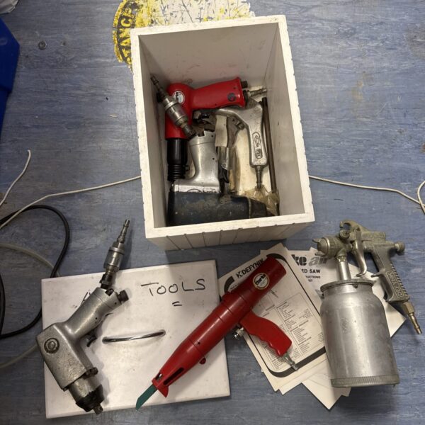 Vintage pneumatic tool set in wooden box, including hammer and drill.
