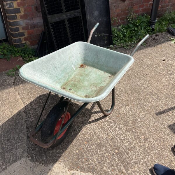Vintage wheelbarrow in a garden setting, showing rustic charm.