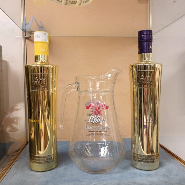 Sealed Au Vodka and Smirnoff bottles with Doctor Pepper pitcher.