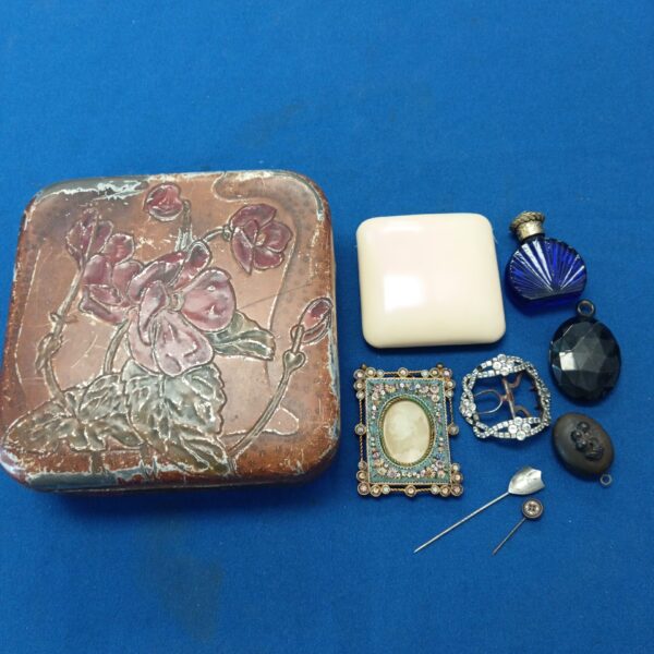 Antique Victorian mourning tin with contents including jewellery and a frame.