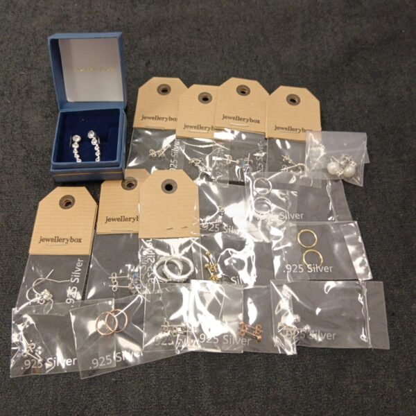 Lot of 18 pairs of 925 silver earrings on display.