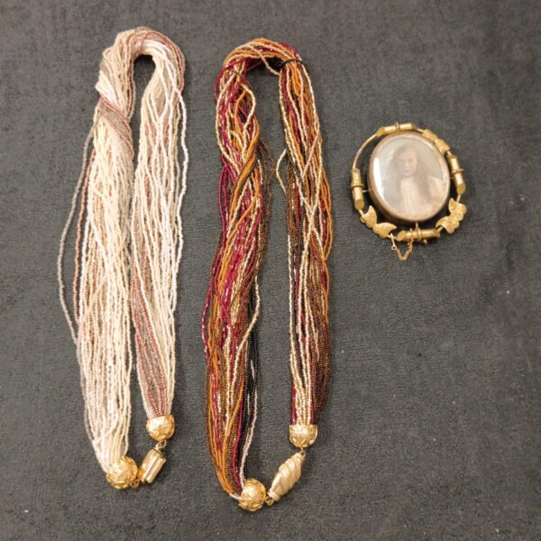 Antique Victorian beadwork necklaces and sweetheart brooch displayed.