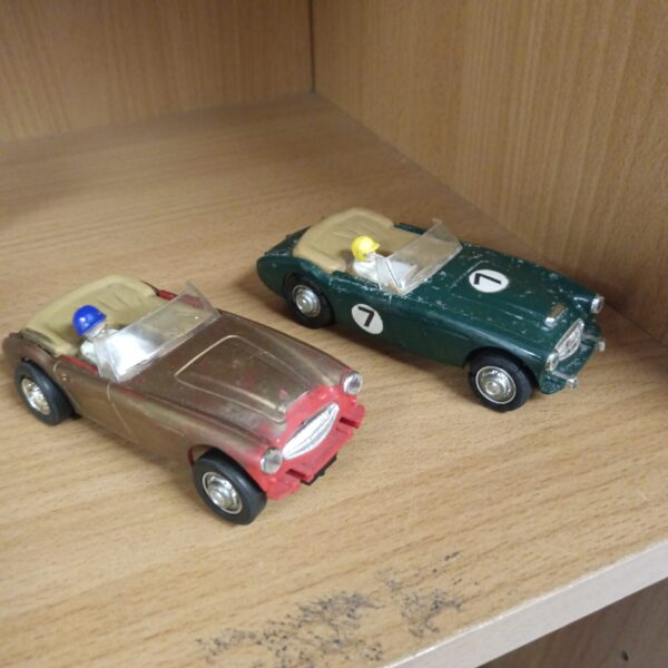 Vintage Scalextric Austin Healey slot cars in red and green.