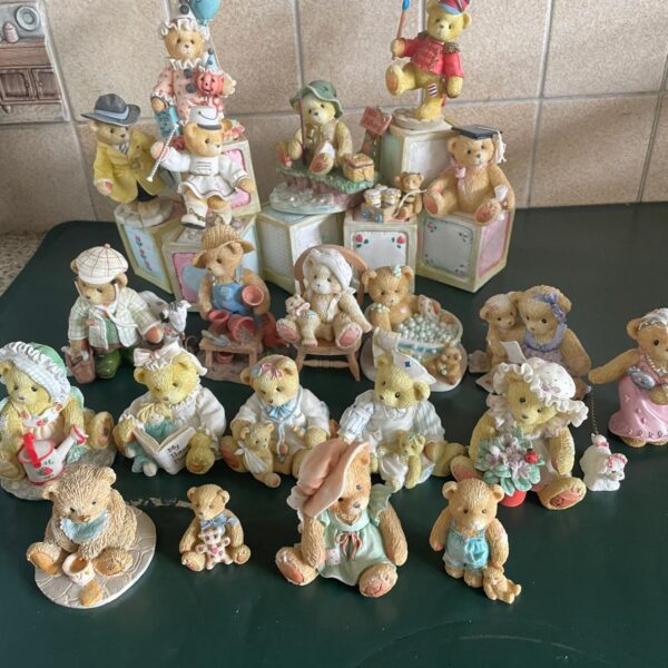 Cherished Teddy figurines collection displayed on a shelf.