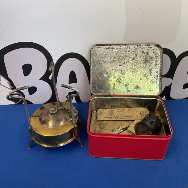 Vintage brass wickless paraffin stove in original enamel tin.