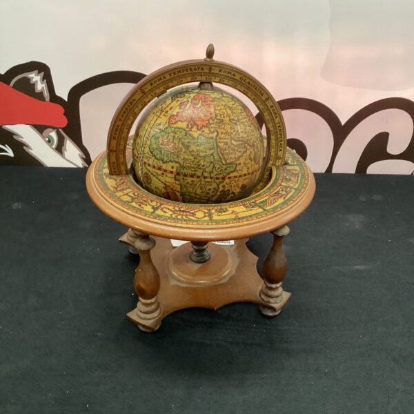 Vintage desktop globe with detailed world map on wooden stand.