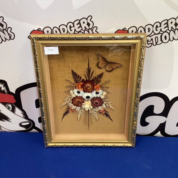 Vintage pressed flower art in a gold frame, delicate floral arrangement.