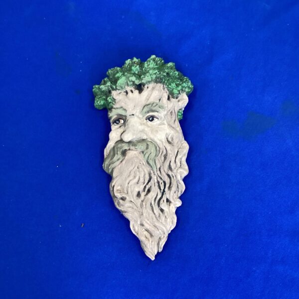 Detailed Green Man wall plaque with foliage and a bearded face.