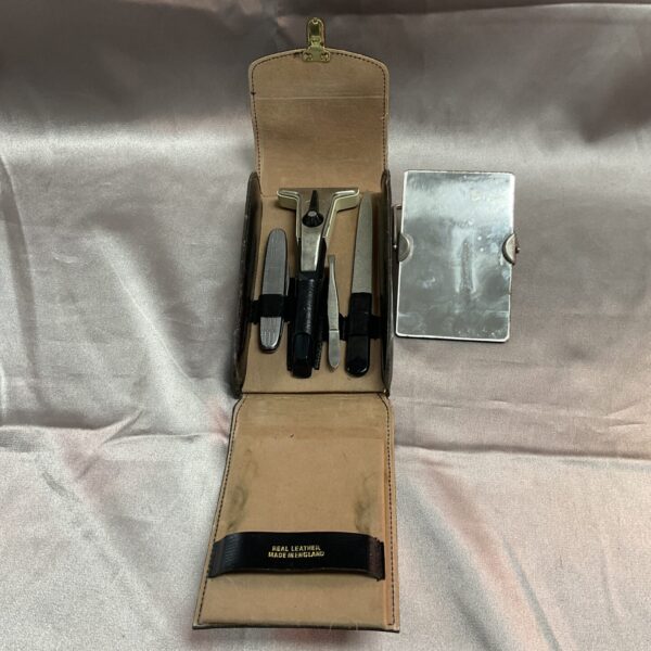 Closed vintage leather shaving set with grooming tools inside.