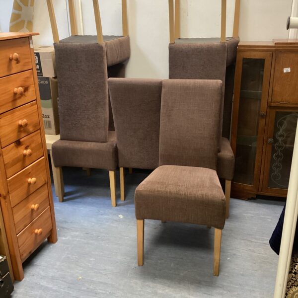 Set of six brown upholstered dining chairs with wooden legs.